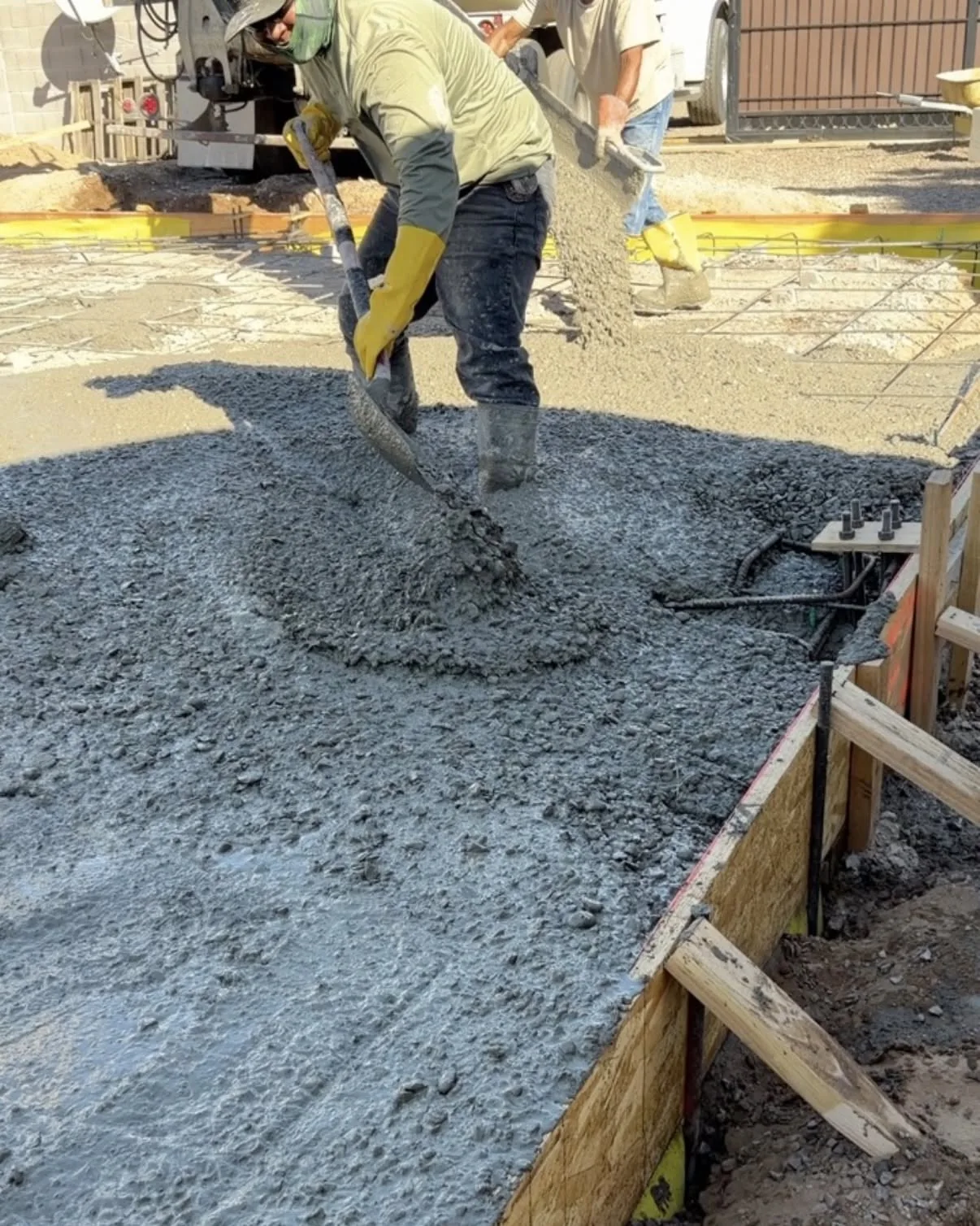 Crew pouring concrete into forms at a construction site