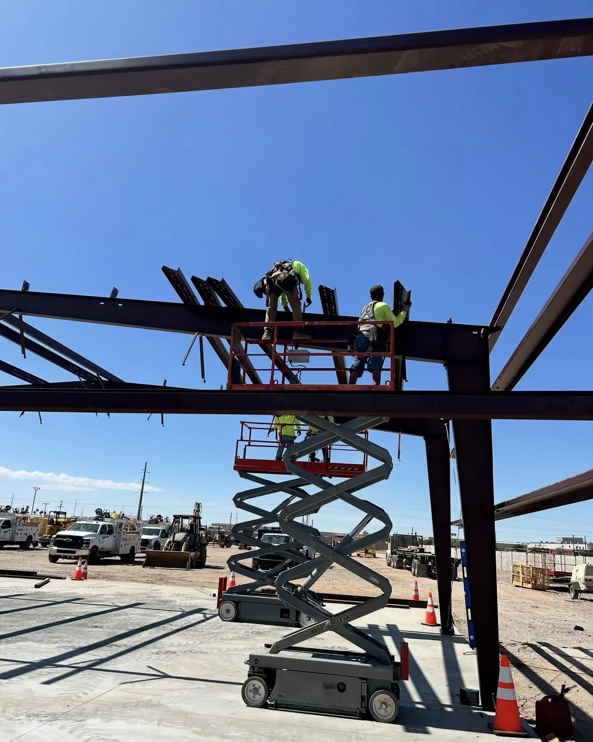 Construction crew on a lift installing a steel building frame