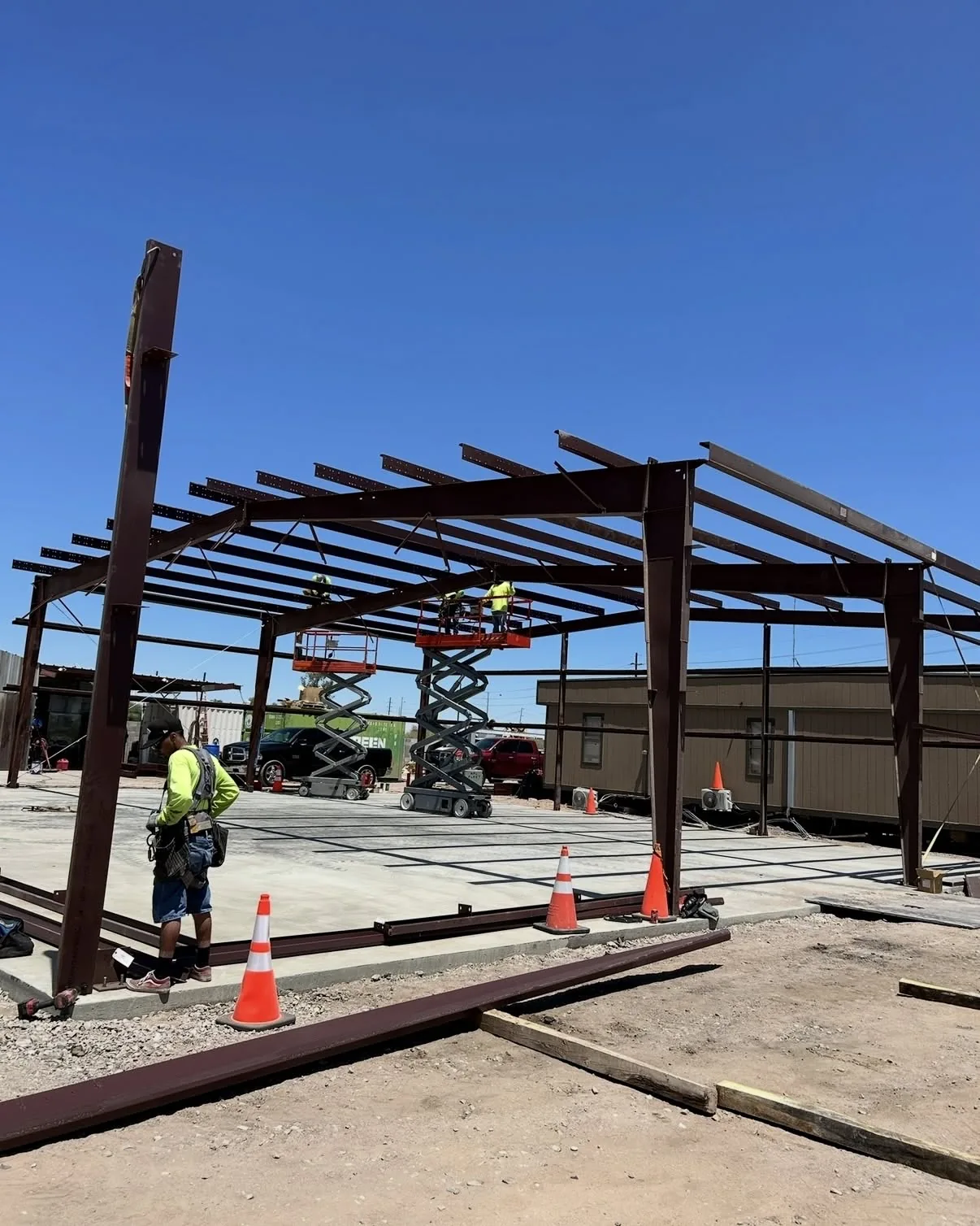 Scissor lift beneath a steel building frame