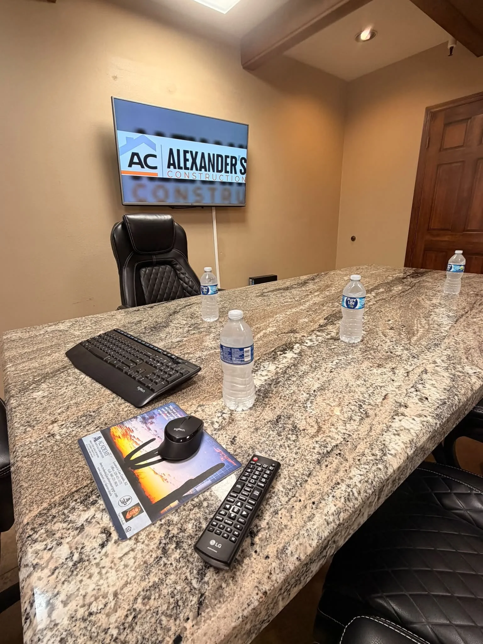 Office meeting space with the Alexander’s Construction logo on the screen