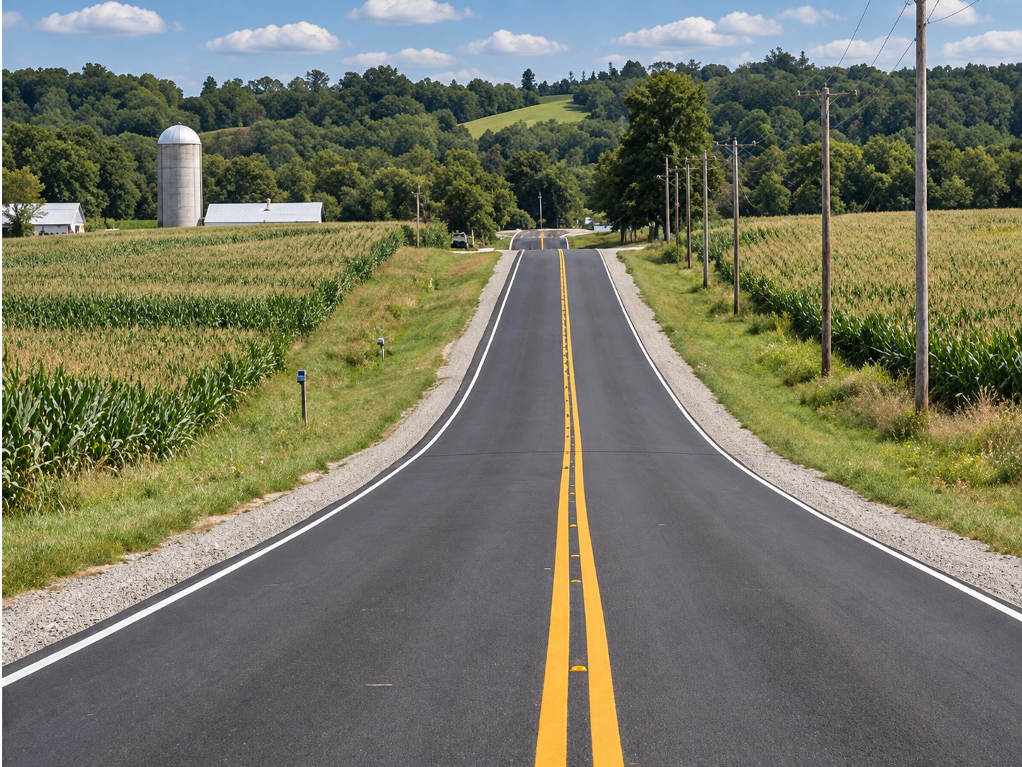 Two-lane rural road running through rolling farmland