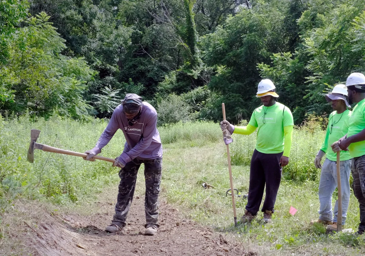 Landforce crew members building a trail