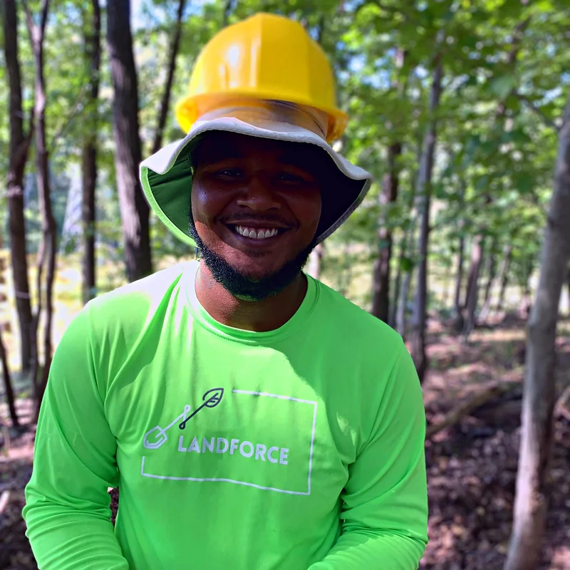 A smiling Landforce crew member in a hard hat
