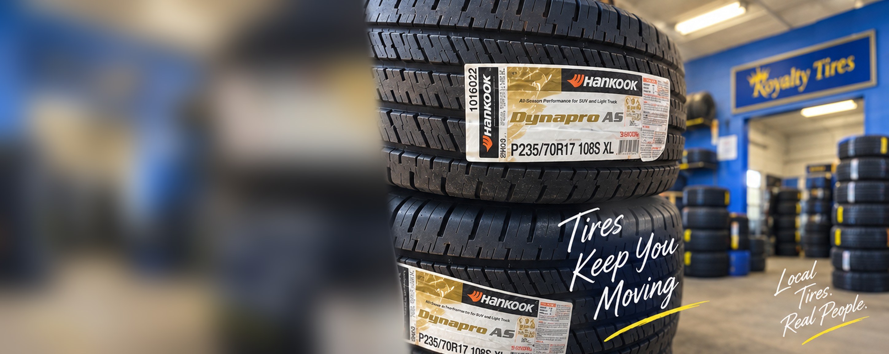 Stacked new tires in front of the Royalty Tires shop interior