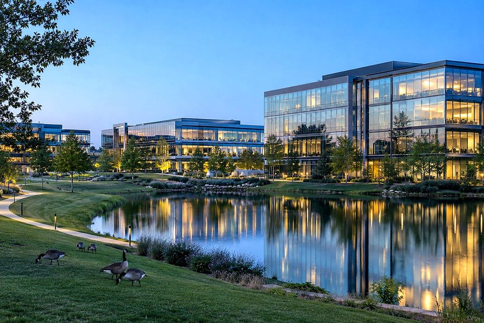 Glass office campus beside a pond and trail