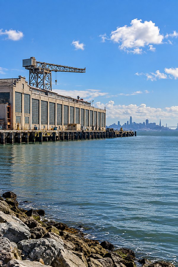 The Richmond waterfront at Ford Point, a shipyard gantry crane above the old factory buildings and the San Francisco skyline beyond the bay