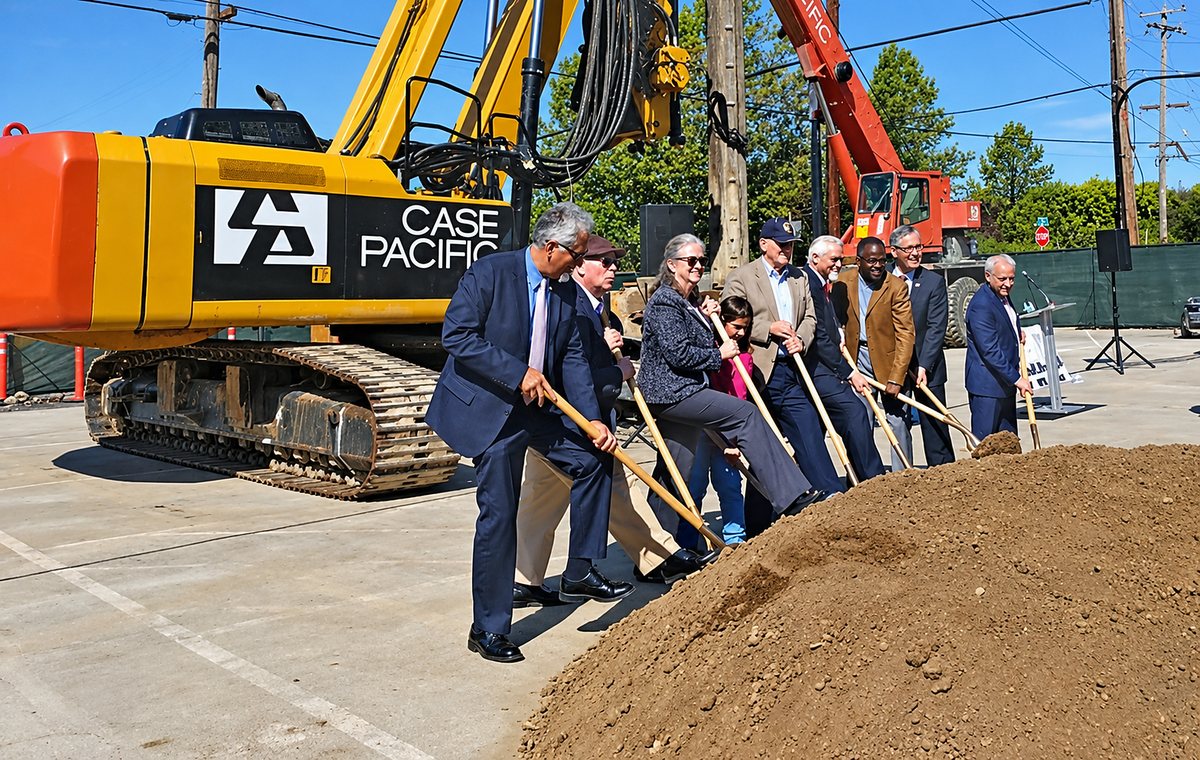 Officials turning earth with shovels at a project groundbreaking